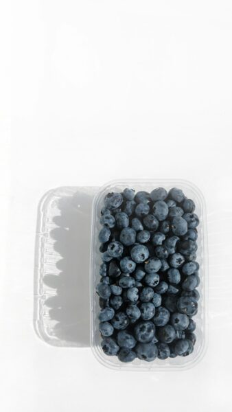 A plastic container filled with blueberries on top of a table