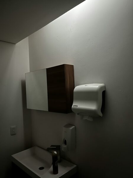 A bathroom with a white sink and a white urinal