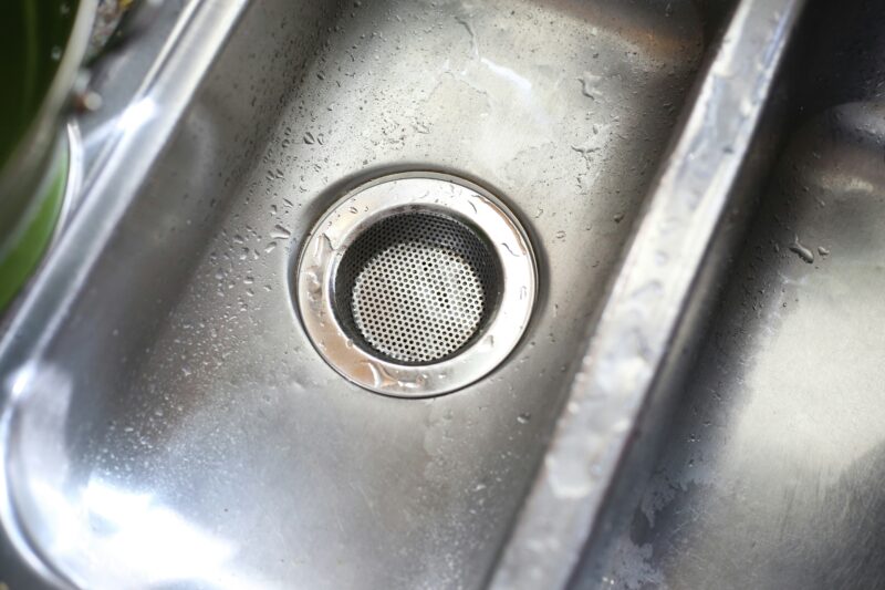 A stainless steel sink with a strainer in it.