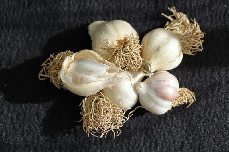 A bunch of garlic sitting on top of a black table