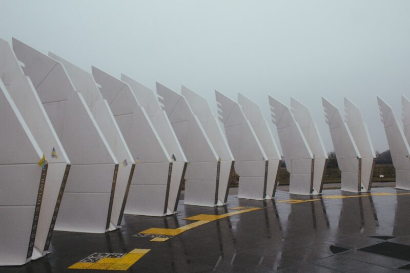 A row of white chairs sitting on top of a wet parking lot