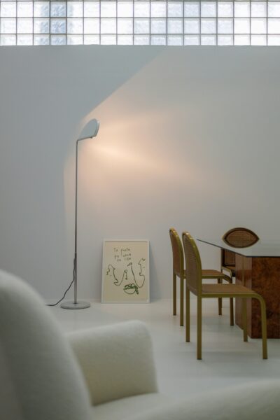 A living room with a white couch, a table, and a lamp