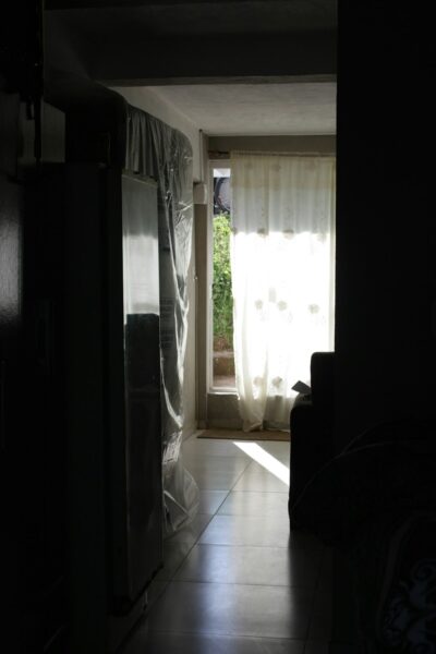 A dark hallway with a window and curtains