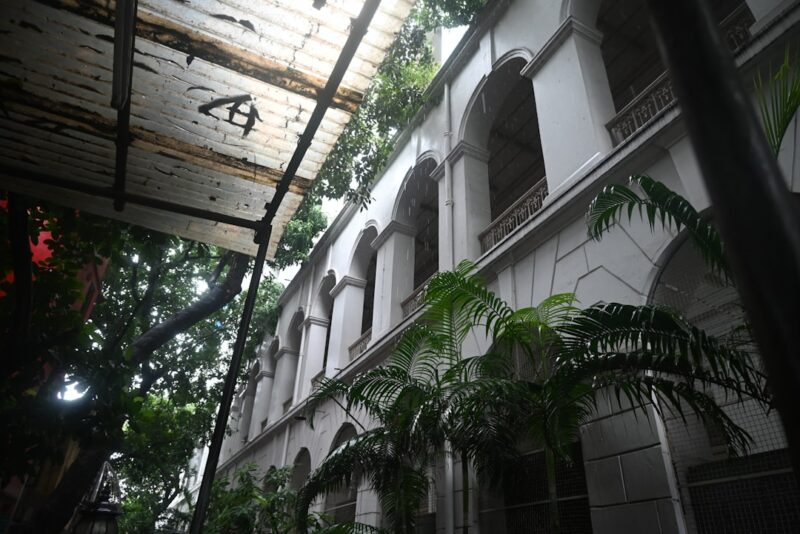 A historical building with arches and greenery