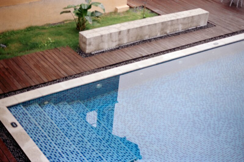 A swimming pool with steps and wooden decking