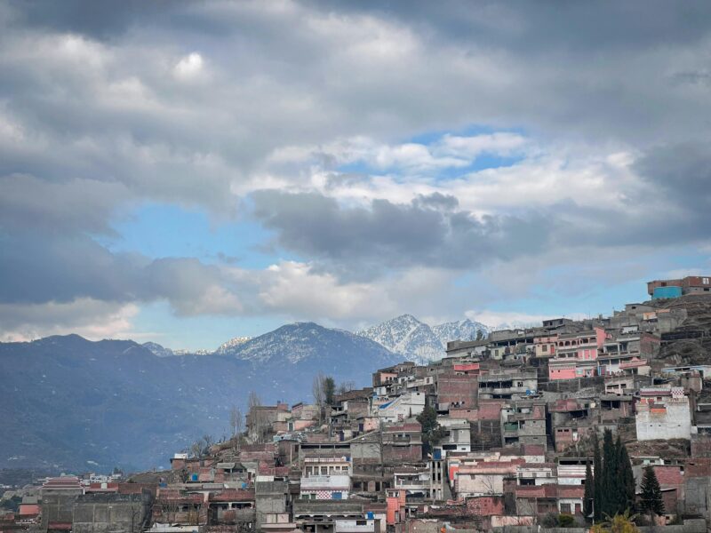 Scenic mountain village under cloudy skies.