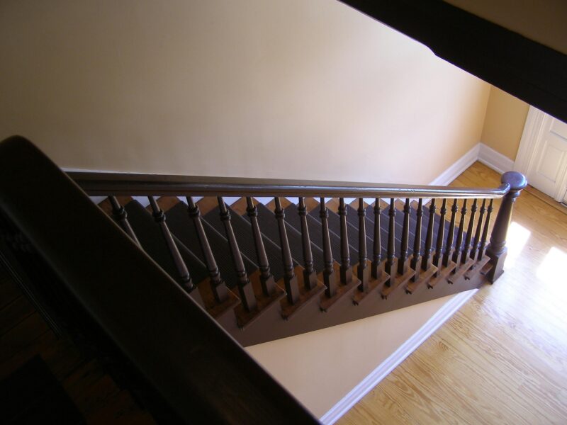 Charming wooden staircase with a detailed handrail inside a home, offering a warm and inviting ambiance.