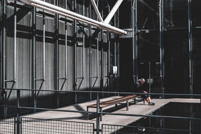a person sitting on a bench in front of a building