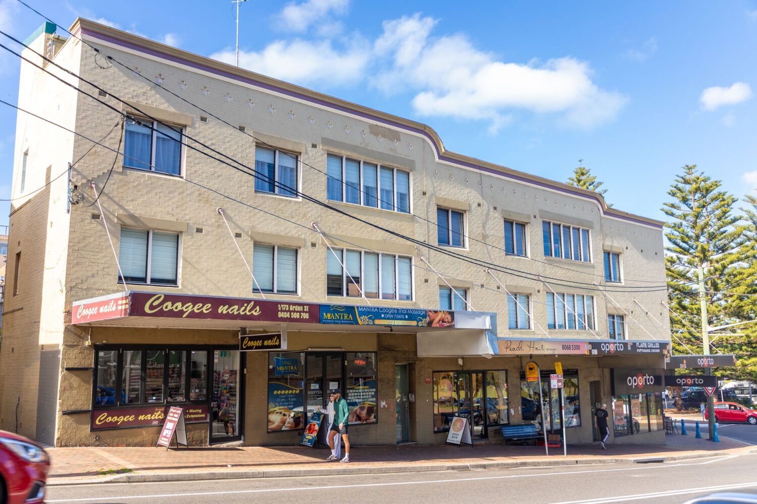 Shops below apartments show how mixed-use frontage keeps a neighborhood street active.