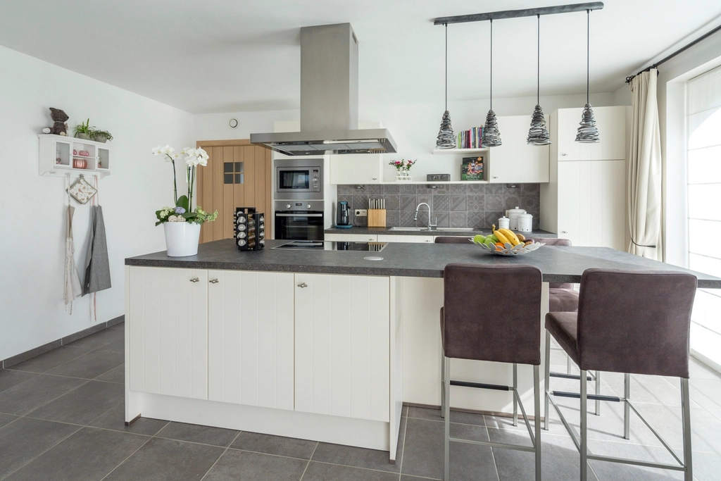 Textured concrete finish backsplash in a small urban-style apartment kitchen setting.