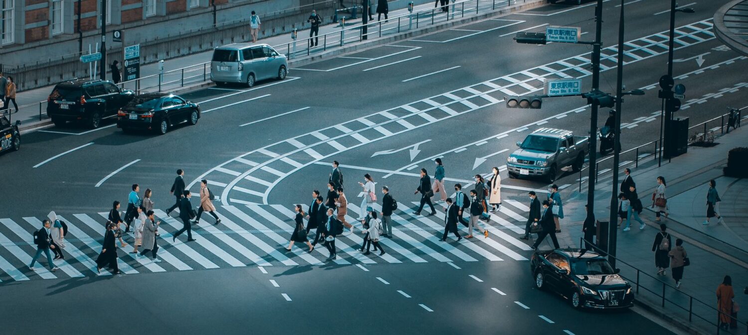 A busy crosswalk shows how pedestrian-priority crossings organize movement in active city streets.