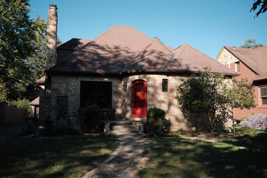 A stone house with a red door and chimney.
