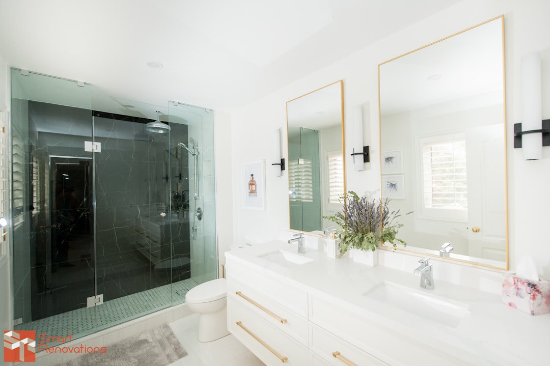 a bathroom with two sinks, a toilet and a shower