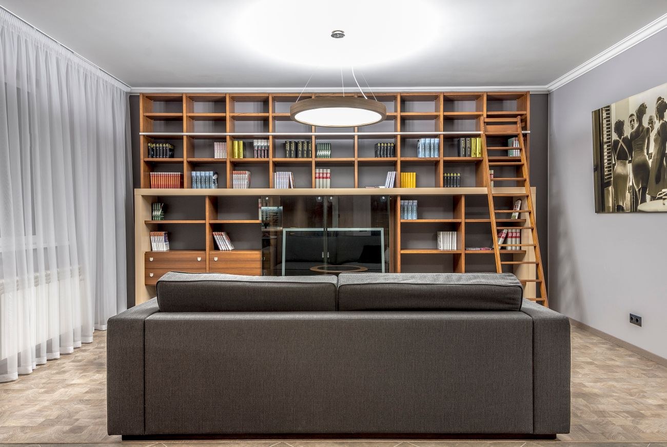 Living room with a large bookshelf, sofa, and warm lighting