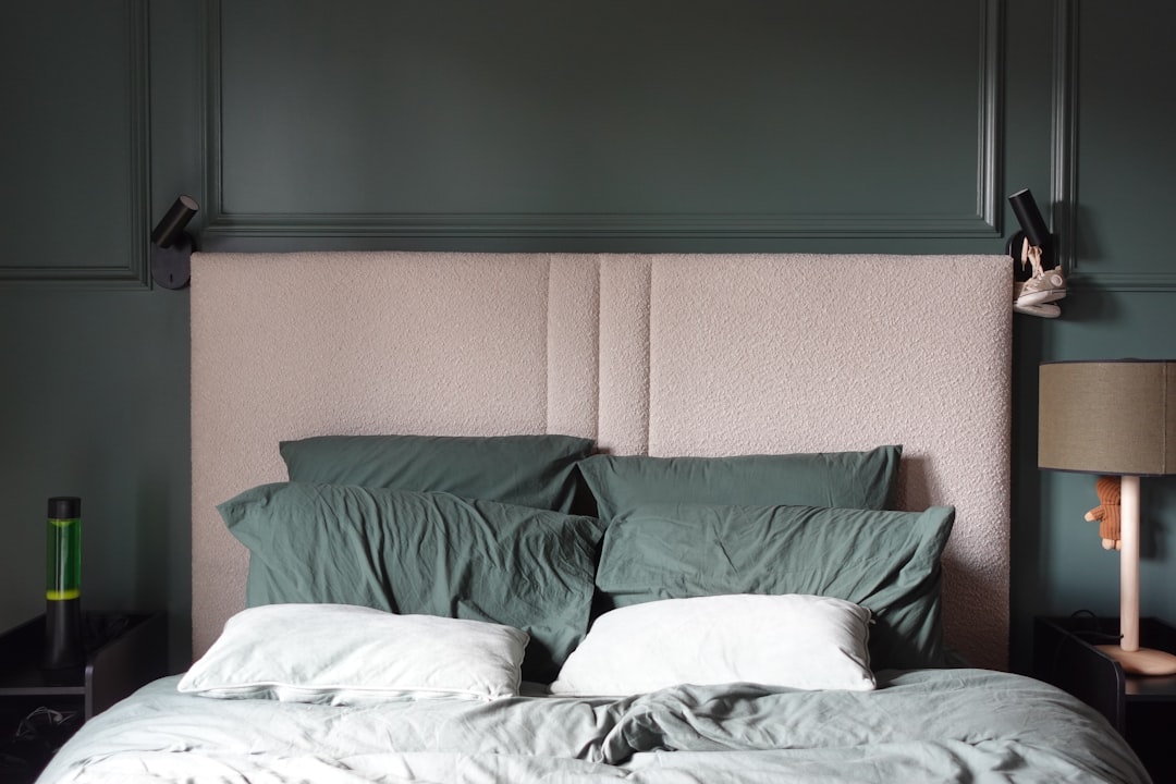 Moody green bedroom styling with bedside lighting