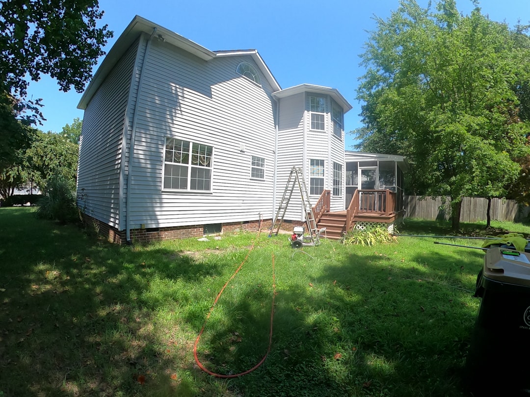 white and brown wooden house near green trees under blue sky during daytime