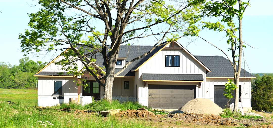 A modern house under construction with trees.