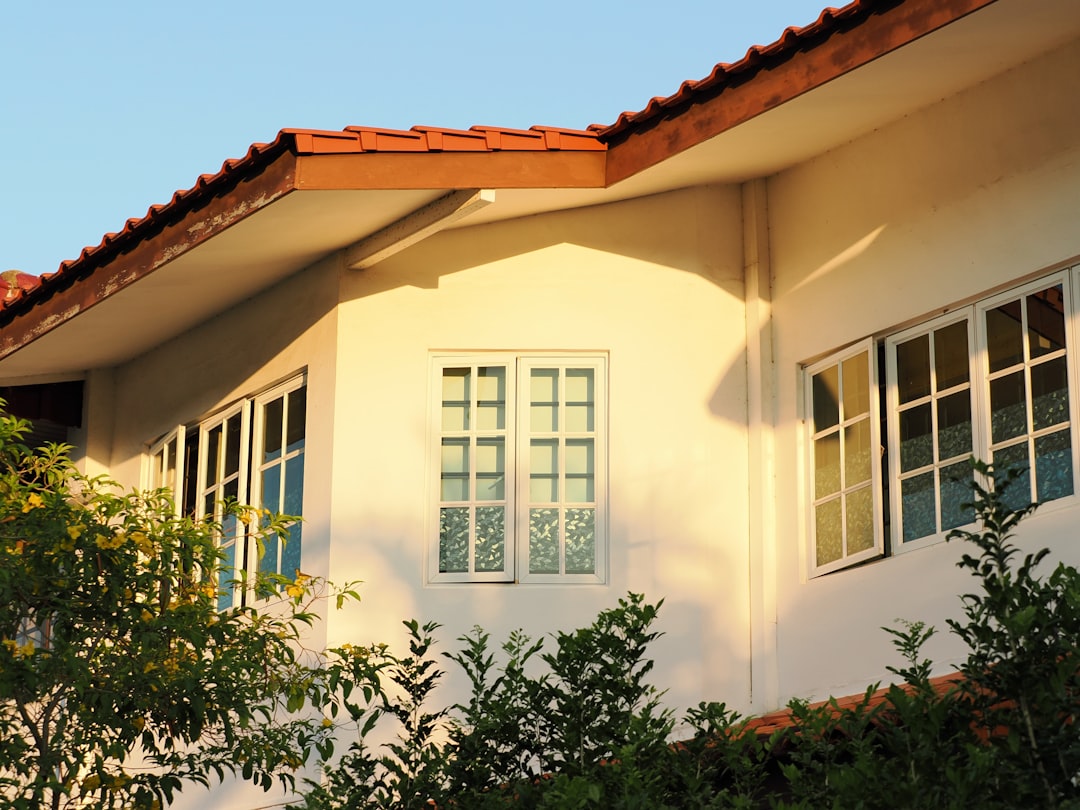 White house with red tiled roof and green bushes