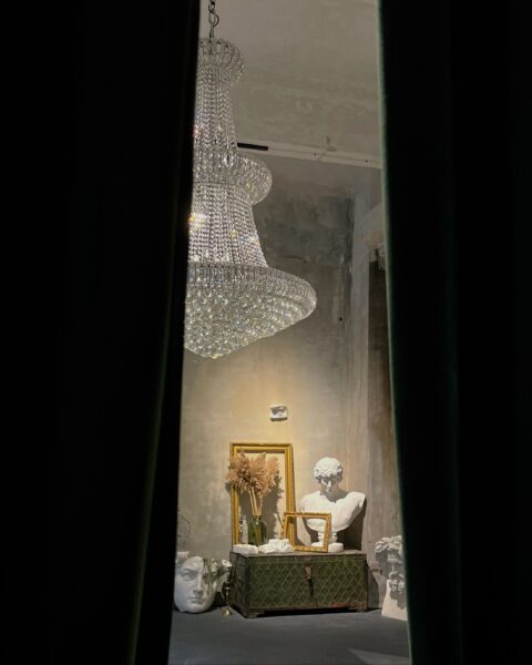 Stunning interior featuring a grand crystal chandelier and classical sculptures for a luxurious ambiance.