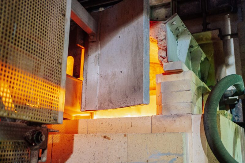 Close-up view of a working glass furnace in an industrial setting, showcasing high-temperature operations.