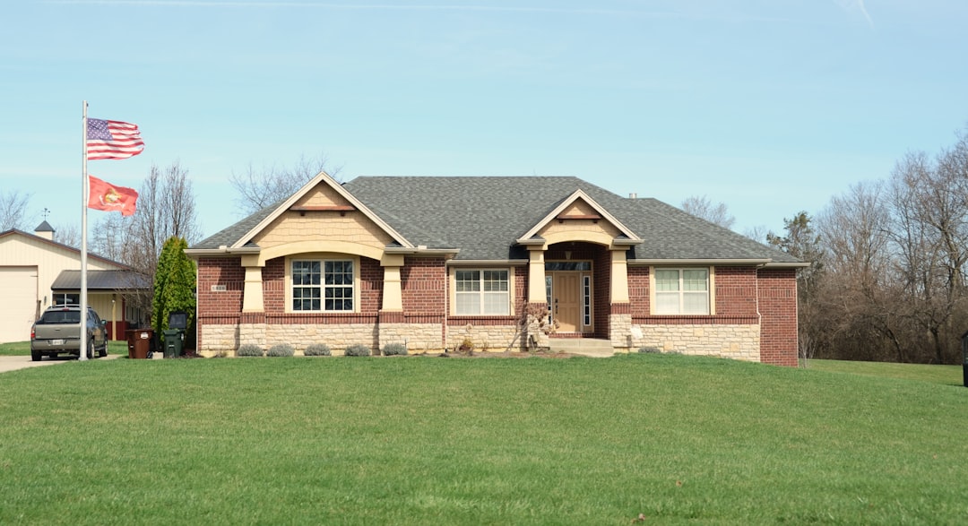 A modern brick house with a large green lawn.