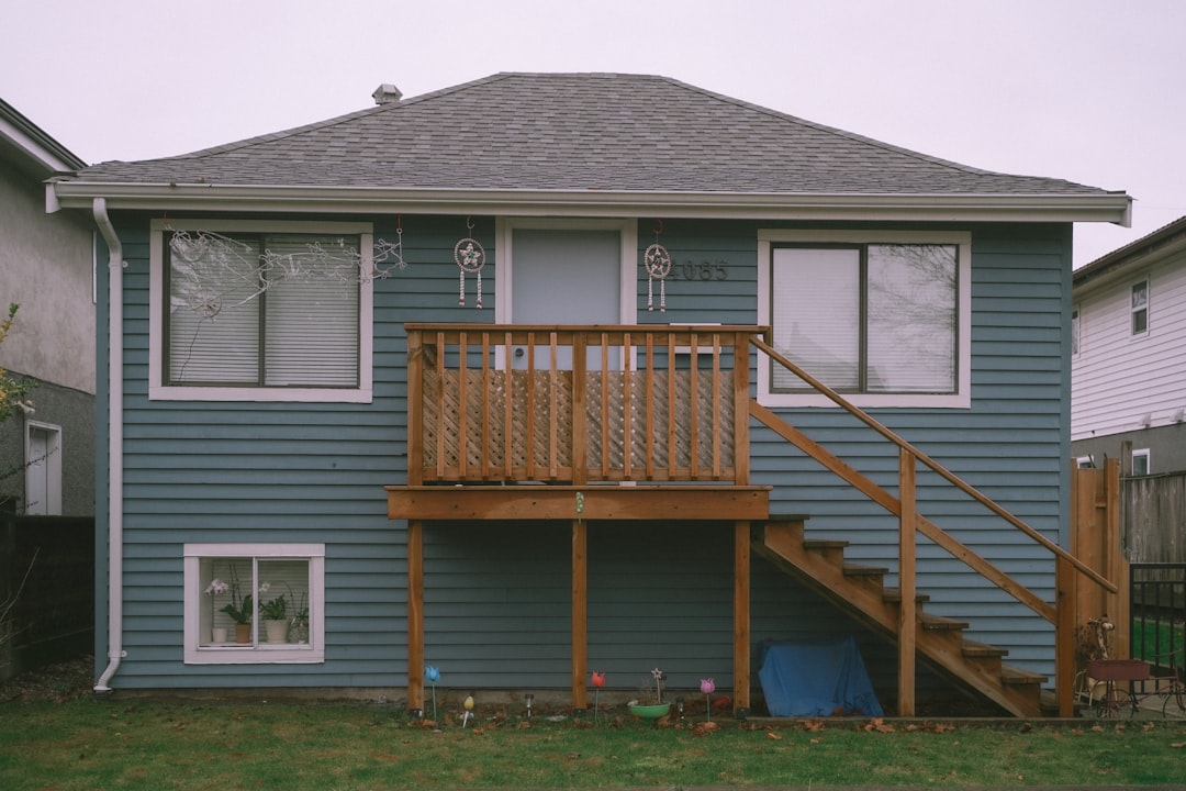 a blue house with a wooden deck in front of it