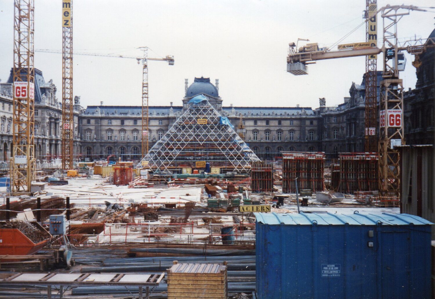 The Louvre Pyramid’s glass and steel frame creates a striking modern entrance amid historic Parisian architecture.
