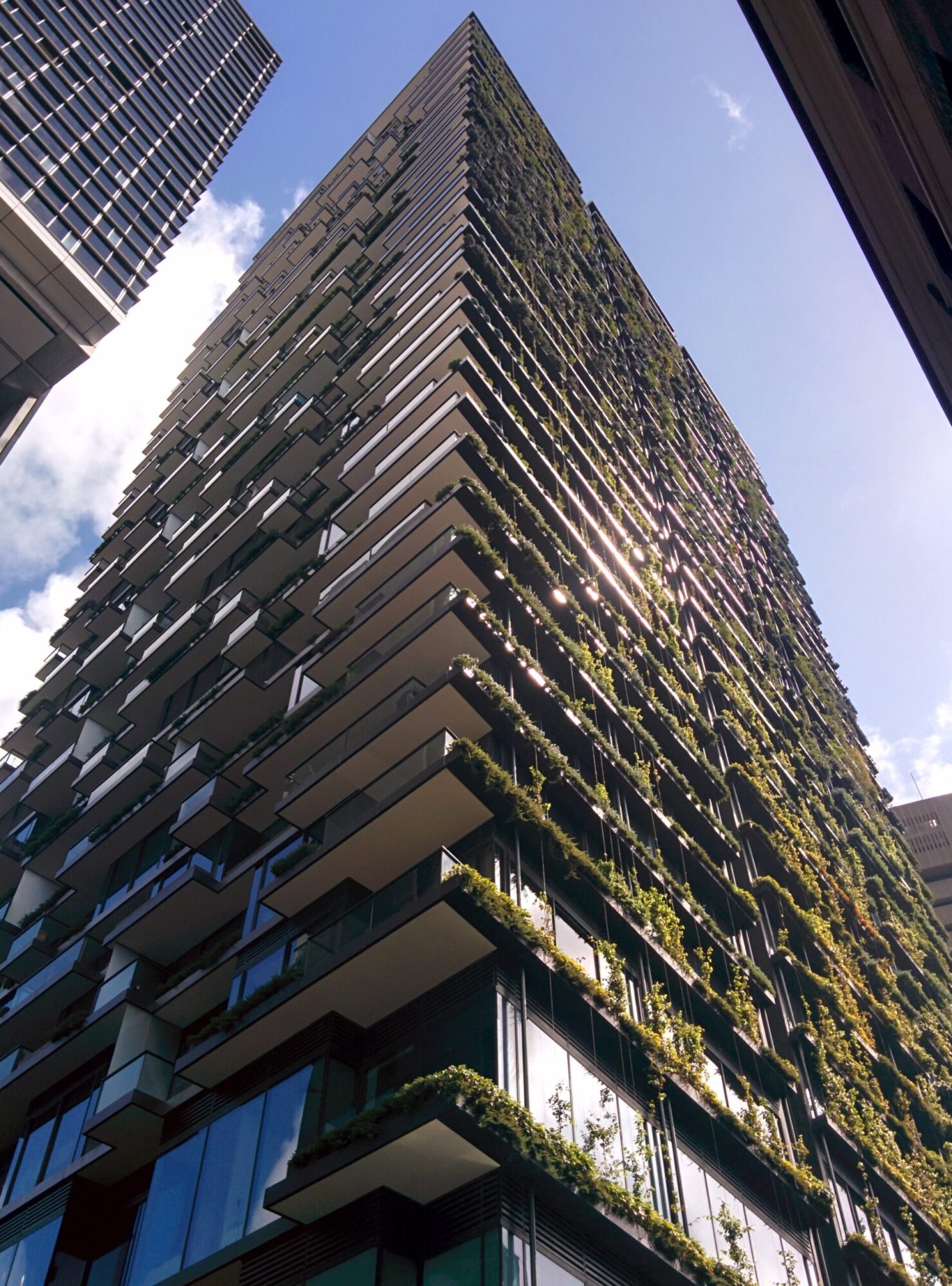 High-rise mixed-use building with extensive vertical gardens and cantilevered heliostat in Sydney.