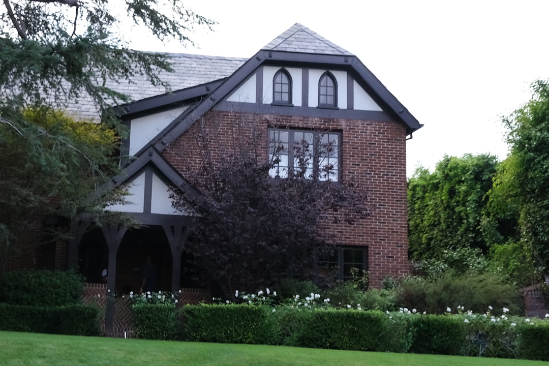Brick house with dark trim and manicured garden