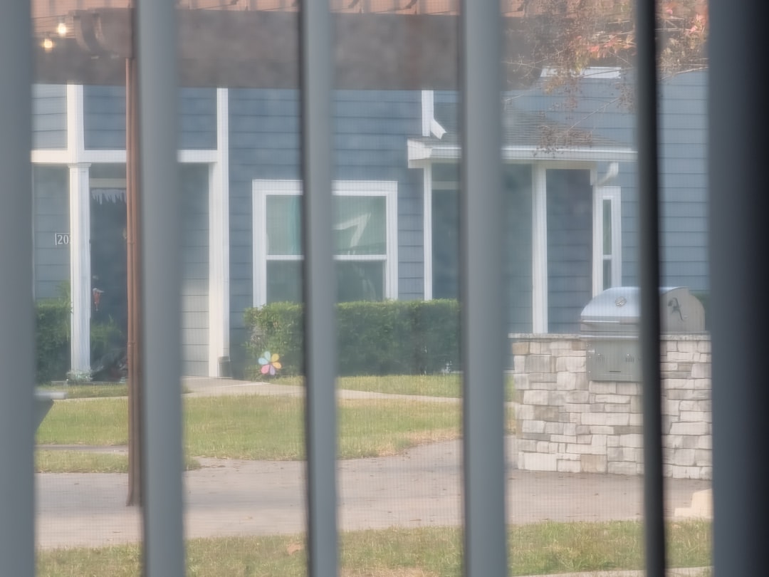 View of a blue house through window blinds