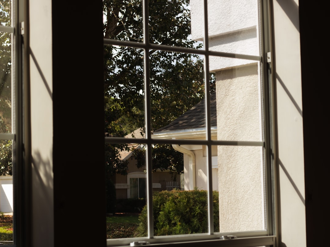 a window with a view of a house and trees