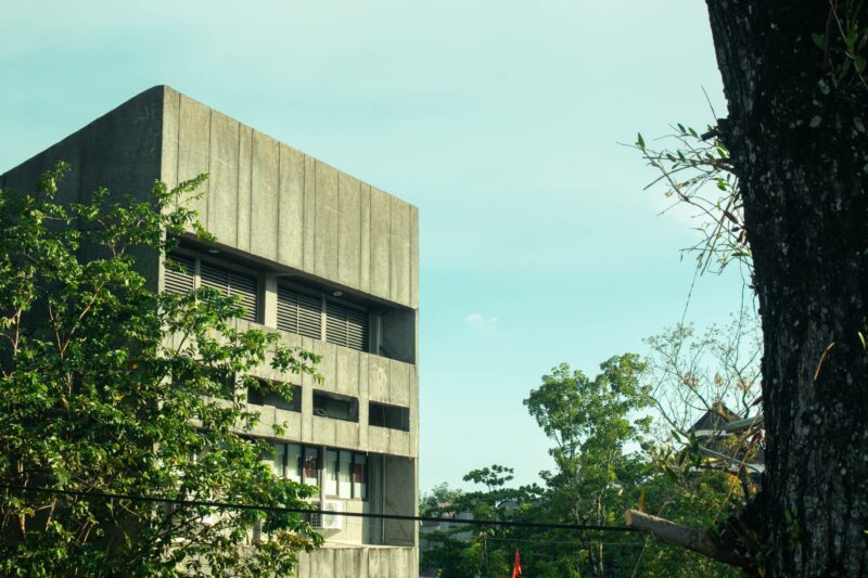 A concrete building with greenery, embodying a mix of urban architecture and nature.