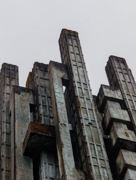 Dramatic view of a brutalist concrete structure with an overcast sky backdrop.